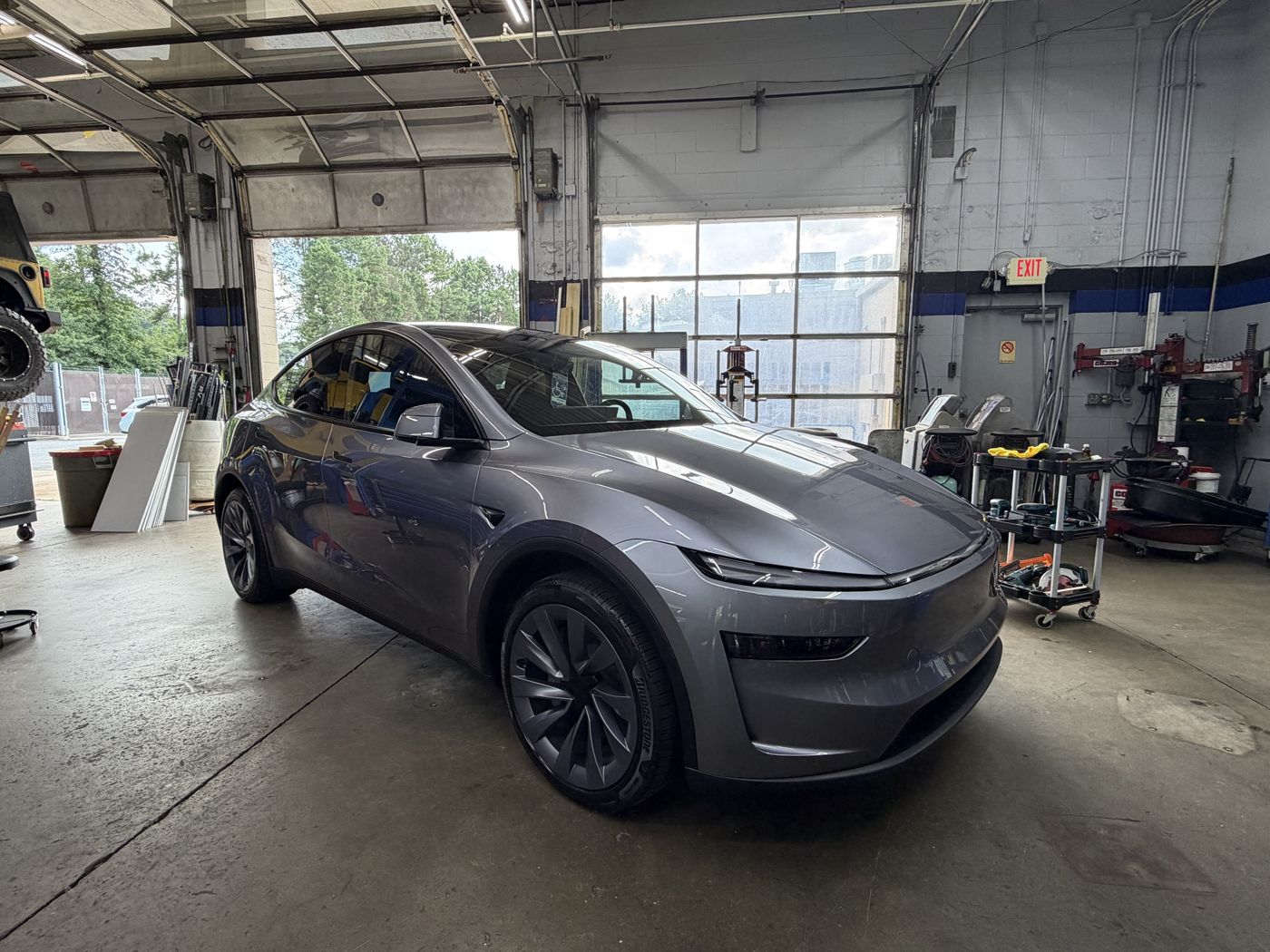 Tesla Model Y with Bridgestone tires in a Grand Tires service bay in Duluth, GA